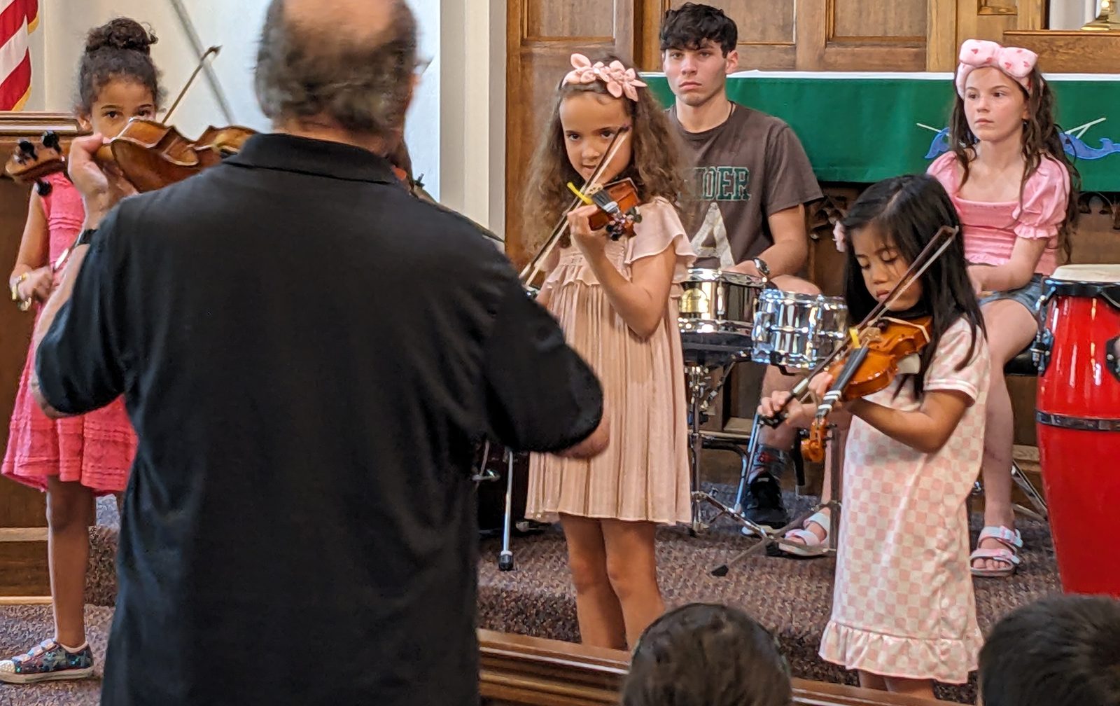An NJWA teacher leading young violin students in a lesson